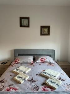 a bed with three pillows on top of it at Apartman Arcobaleno in Vrnjačka Banja