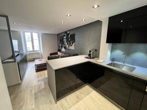 een keuken met een wastafel en een woonkamer bij Appartement Design Centre ville in Saint-Tropez