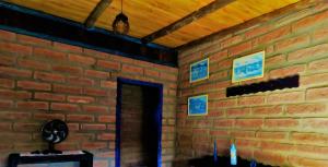 a brick room with a brick wall and a doorway at Hostel CASA DA PEDRA CHATA in Torres