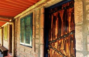 a building with a wooden door and a window at Hostel CASA DA PEDRA CHATA in Torres