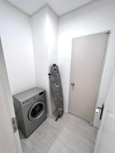 uma lavandaria com uma máquina de lavar roupa e uma porta em The Trust Highvill Ishim D em Astana