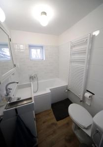 La salle de bains est pourvue d'une baignoire, de toilettes et d'un lavabo. dans l'établissement Étoile Apartman, à Eger