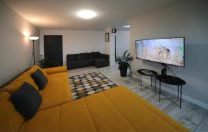 Il comprend un salon doté d'un canapé et d'une télévision à écran plat. dans l'établissement Étoile Apartman, à Eger