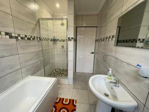 a bathroom with a tub and a sink and a shower at Cozy Inn in Tikoe