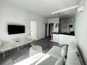 ein Wohnzimmer mit einem Sofa und einer Küche in der Unterkunft Alexander Suites in Drios