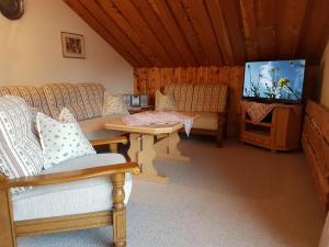 uma sala de estar com sofás e uma televisão de ecrã plano em Landhaus Reiser em Grainau