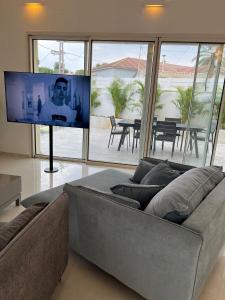 a living room with a couch and a flat screen tv at Luz Mansion ~ Lux & Comfy in Rishon LeẔiyyon