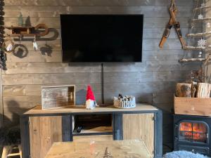 einen Fernseher an einer Holzwand mit einem Santa-Hut auf einem Tisch in der Unterkunft Charmant T2 La Foux d’Allos, 5 pers in Allos