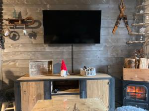 une télévision sur un mur en bois avec un chapeau de santa sur une table dans l'établissement Charmant T2 La Foux d’Allos, 5 pers, à Allos