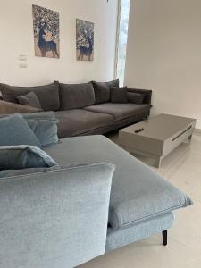 een woonkamer met een bank en een salontafel bij Luz Mansion ~ Lux & Comfy in Rishon LeẔiyyon