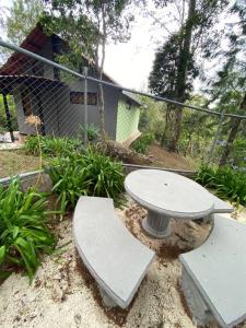 una mesa de hormigón y un banco en un jardín en Koi's House - Quebradillas de Dota, en Santa María