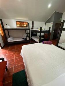 1 dormitorio con 2 camas en una habitación con suelo de madera en Koi's House - Quebradillas de Dota, en Santa María