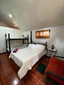 a bedroom with a white bed and a window at Koi's House - Quebradillas de Dota in Santa María