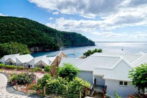 una vista de una fila de casas junto al agua en LES GALETS ROUGES LODGES & SPA en Bouillante