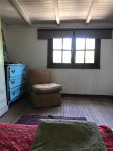 サン・アントニオ・デ・アレコにあるCasa Fuegoのベッドルーム(椅子、ドレッサー、窓付)