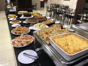 una línea de buffet con muchos tipos diferentes de comida en Hotel Estação Express, en Curitiba