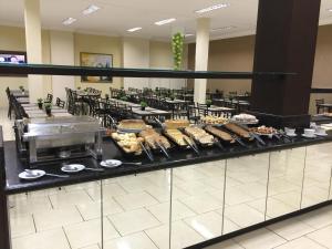 una línea de buffet con muchos tipos diferentes de comida en Hotel Estação Express, en Curitiba