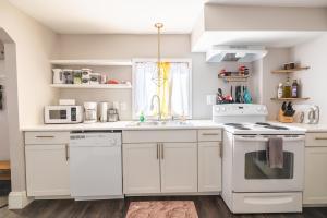 a kitchen with white cabinets and a white stove top oven at Relaxed Asheville Apartment - Pet-Friendly in Asheville +16 photos