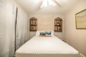 a small bedroom with a white bed with two pillows at Relaxed Asheville Apartment - Pet-Friendly in Asheville