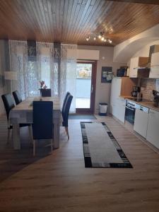 uma cozinha e sala de jantar com mesa e cadeiras em Ferienhaus Heimes em Klotten