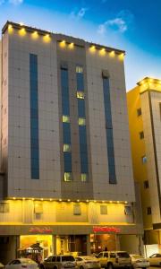 um grande edifício com carros estacionados em frente em برج الشمال للشقق الفندقية Burj ALShamal em Tabuk