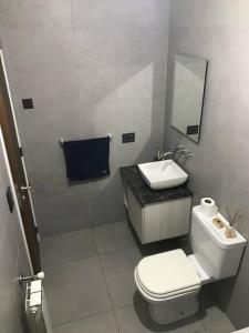 y baño con aseo blanco y lavamanos. en Hermoso departamento en complejo PREMIUM en Córdoba