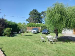 ein Tisch und Stühle in einem Hof mit einem Baum in der Unterkunft Complejo Las Palmeras in Tandil + 1 Foto