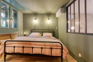 a bedroom with a bed and a window at Au Noeud Vert Chambres d'hôtes in Nevers