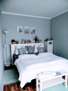 1 dormitorio con 1 cama blanca grande y paredes azules en Bomi Apartman, en Győr