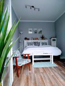 1 dormitorio con cama blanca grande y banco en Bomi Apartman, en Győr