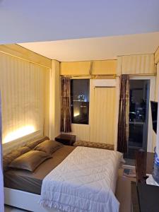 a bedroom with a large bed and two windows at Paradise Room By Vivo Apartment in Seturan