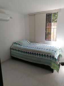 a bed in a white room with a window at Lilia's House Santa Marta in Santa Marta