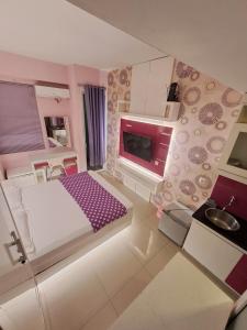 a small room with a bed and a tv at Paradise Room By Vivo Apartment in Seturan