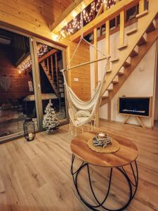 une chambre avec un hamac et une table dans une cabine dans l'établissement Loft&Hill, à Grywałd