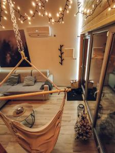 a hammock in a room with a bed and lights at Loft&Hill in Grywałd