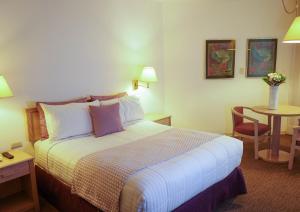 Säng eller sängar i ett rum på Hotel San Marcos Grand