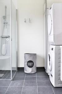 a bathroom with a washer and dryer next to a washing machine at Mysigt hus med kamin och pool in Torekov