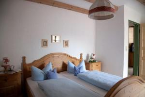 um quarto com uma cama com almofadas azuis em Landhaus Reiser em Grainau
