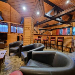 a waiting room with leather chairs and a bar at Vila Karina in Teşila