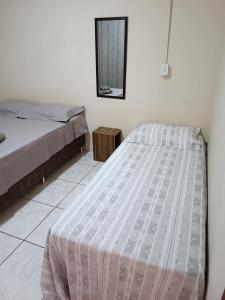 a bedroom with two beds and a mirror at Residencial Joed 4 in Dourados