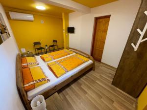 ein Schlafzimmer mit einem großen Bett mit gelben Wänden in der Unterkunft Napsugár Vendégház - Sátoraljaújhely in Sátoraljaújhely