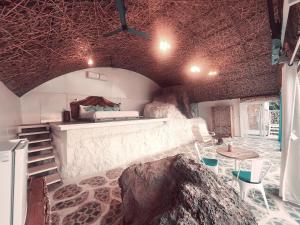 a room with a bed and a table and a rock at Obrigado by Craftels in Cabo de Rama