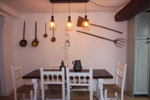 una sala da pranzo con tavolo e alcune luci di Casa Rural La Labranza a Sacedón