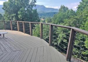 a wooden deck with a table and a view of the mountains at Hawks View Gatlinburg Mountain Cabin in Gatlinburg