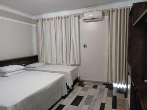 Habitación de hotel con 2 camas y TV en Lodi Express Hotel, en Arapongas