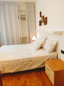 um quarto com uma cama com lençóis brancos e uma mesa em La Casina di Borgo em Borgo San Lorenzo