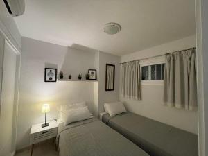 sypialnia z dwoma łóżkami, stołem i oknem w obiekcie Cielomar Benalmadena costa w mieście Benalmádena