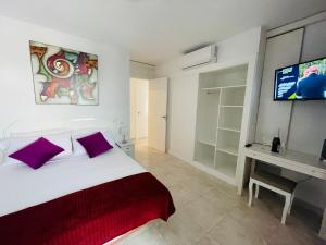 sypialnia z łóżkiem i telewizorem na ścianie w obiekcie Cielomar Benalmadena costa w mieście Benalmádena