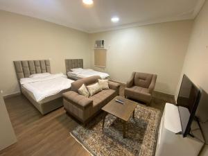 Sala de estar con sofá, cama y TV en شقق مساكن الاميره en Yanbu