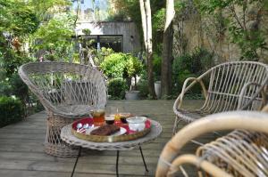 2 sedie e un tavolo con bevande su un patio di Au Noeud Vert Chambres d'hôtes a Nevers